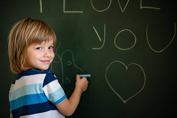 istock Cute boy draws at chalkboard at home 1251405331