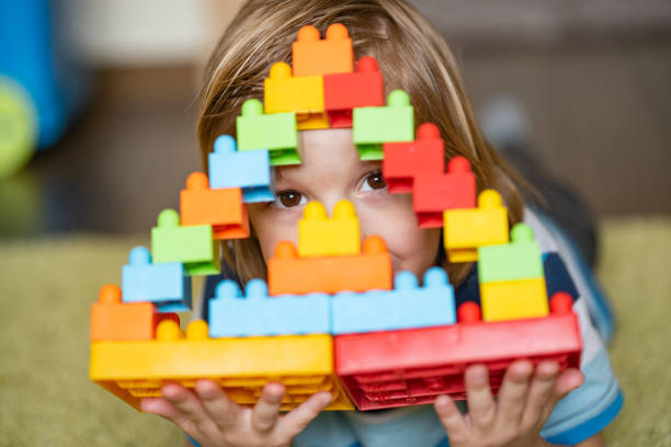 Little boy cover face with his building toy. Close up