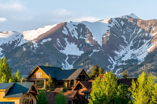mount crested butte colorado village houses in summer with colorful sunset on green trees and lodging - lodging imagens e fotografias de stock
