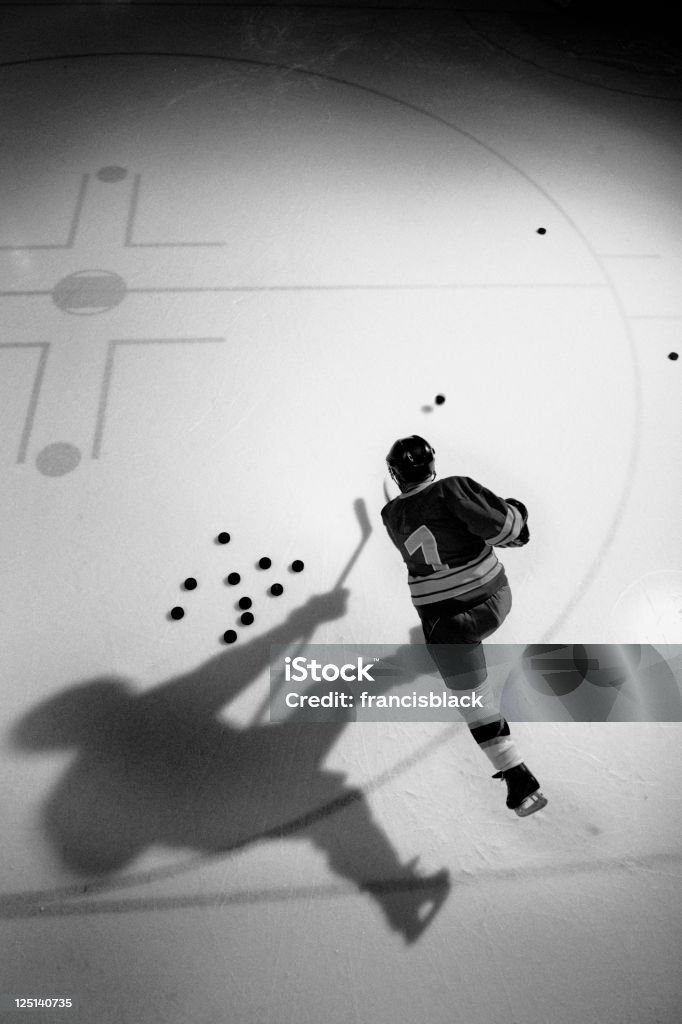 Hockey Player Practicing Hockey player practicing shooting pucks. Ice Hockey Stock Photo
