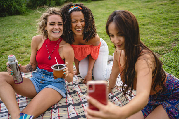 istock Beautiful women taking selfies together while drinking yerba mate on a meadow 1251408032