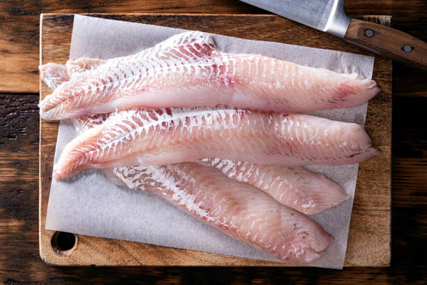 Fresh Haddock Fillets Fresh haddock fillets on a wooden cutting board. haddock stock pictures, royalty-free photos & images