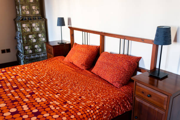 античная винтажная ретро спальня с кроватью в комнате со старомодными украшениями и камином дымохода в доме в европе - antique bed стоковые фото и изображения