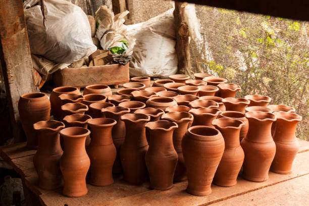 A pile group of chilean classic rustic handmade baked earthenware empty terra-cotta greda clay flower pots for sale at the pottery workshop in Pomaire, Chile