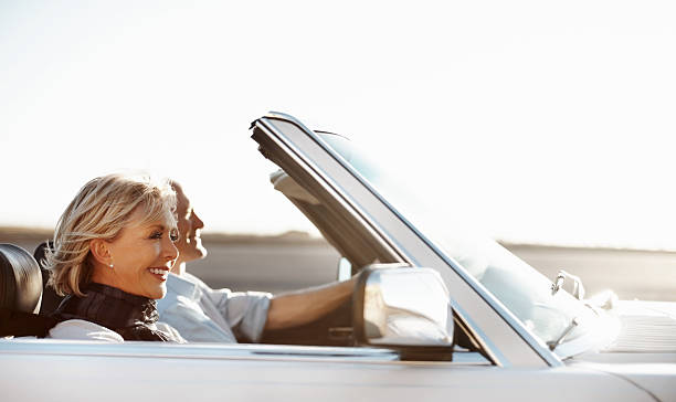 glückliche senior frau reiten in ein auto mit ihrem ehemann vor - attractive couple stock-fotos und bilder