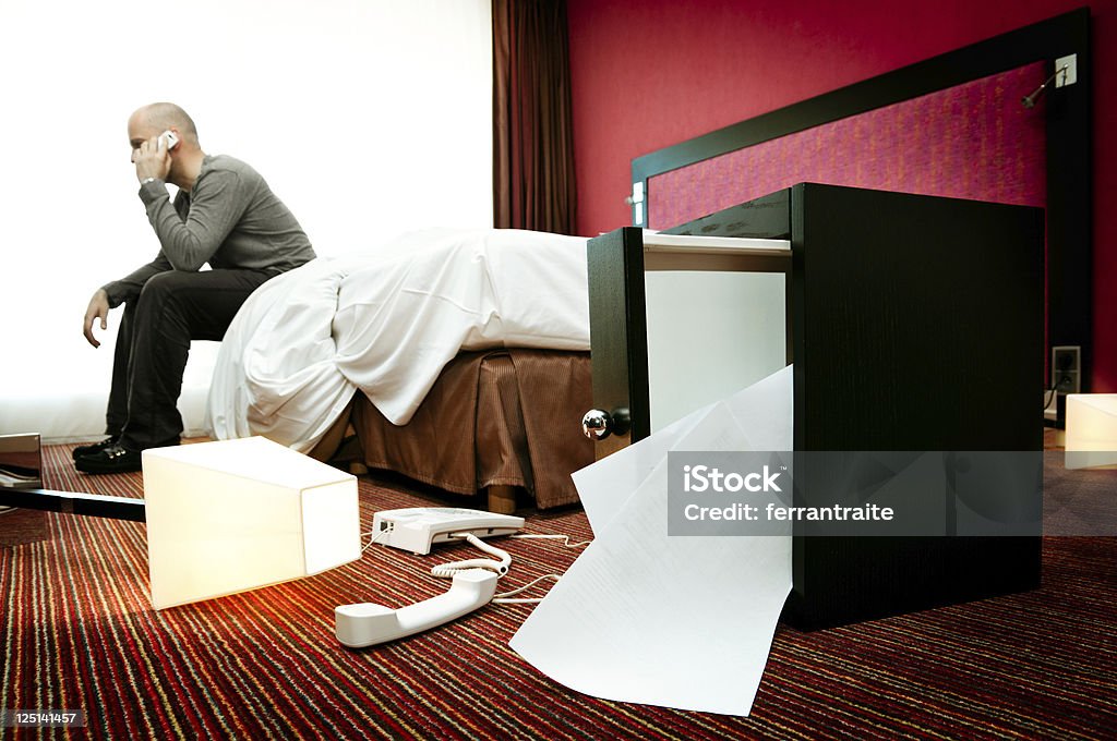 Burglary Man sits on bed calling for help after finding out that someone broke into his appartment. Stealing - Crime Stock Photo