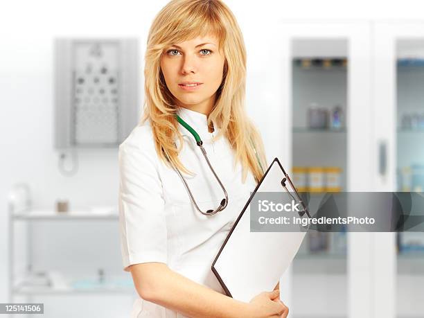 Joven Sonriente Mujer Médico En Blanco Bata De Laboratorio Con Estetoscopio Foto de stock y más banco de imágenes de Adulto