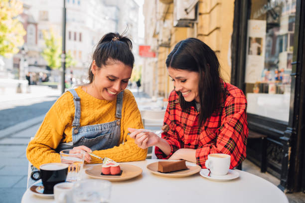istock Twins enjoying coffee and cakes 1251415240