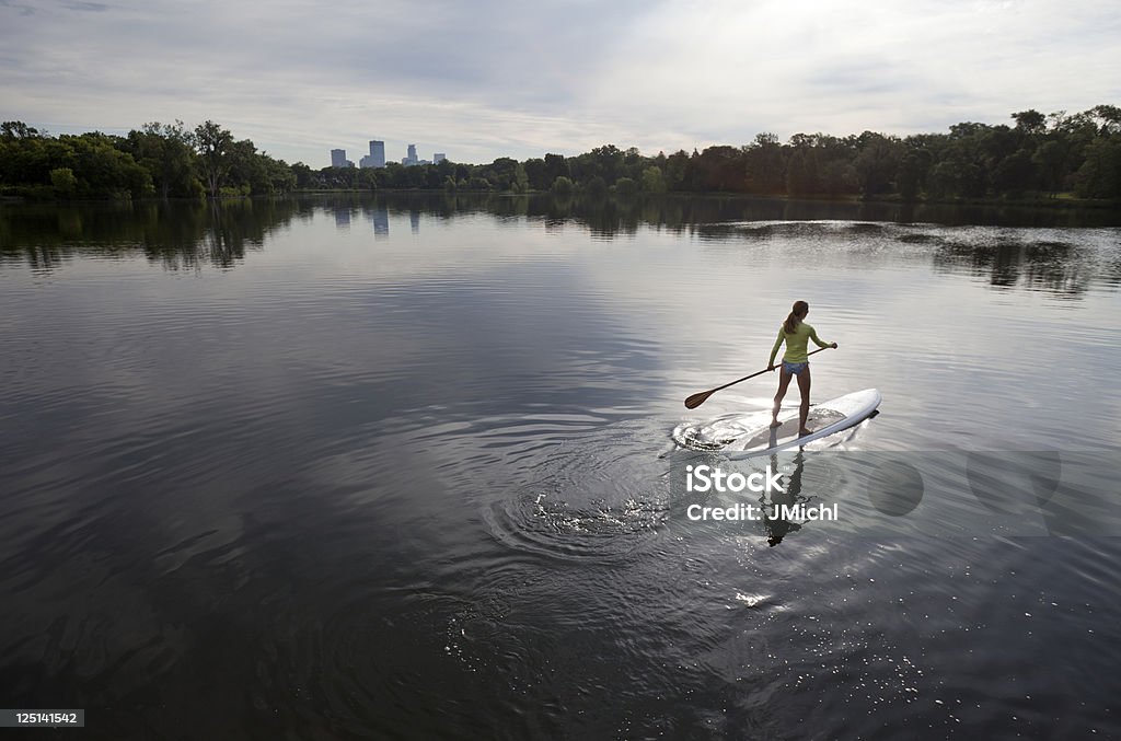 Atletica donna canoa su un lago tranquillo del Midwest. - Foto stock royalty-free di Minneapolis
