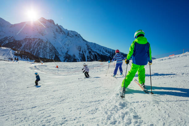 istock Ski school kids racing down in morning light 1251415487