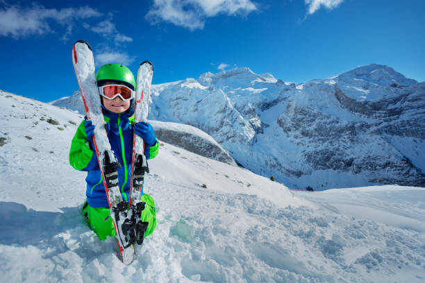 istock Happy little boy hugging ski over mountains 1251415503