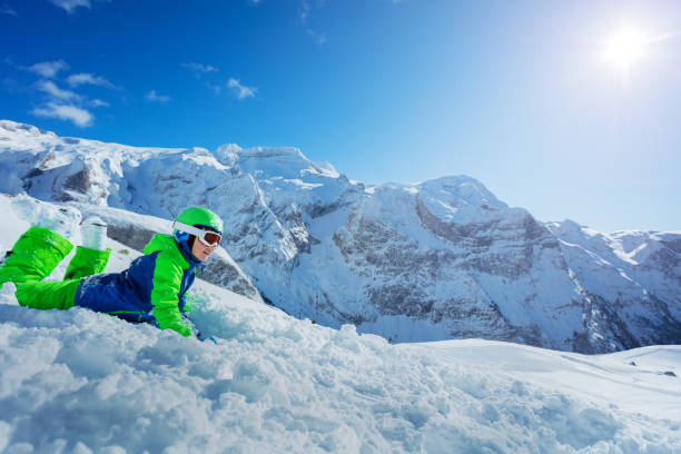 istock Little skier having fun laying in snowy mountains 1251415507