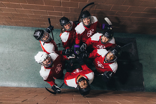 Portrait of a women's hockey team dressed up in their recreation league uniforms. They are posing off ice in a corridor before their game. Image taken in Utah, USA.