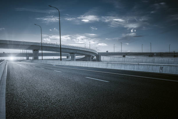 ciel bleu clair et nuages blancs à l’arrière-plan, pont d’approche incurvé de passage supérieur d’autoroute - route déserte photos et images de collection