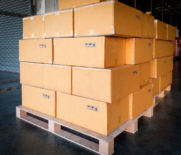istock Stack of cardboard boxes on wooden pallets. shipment boxes, interior of warehouse storage. 1251424877