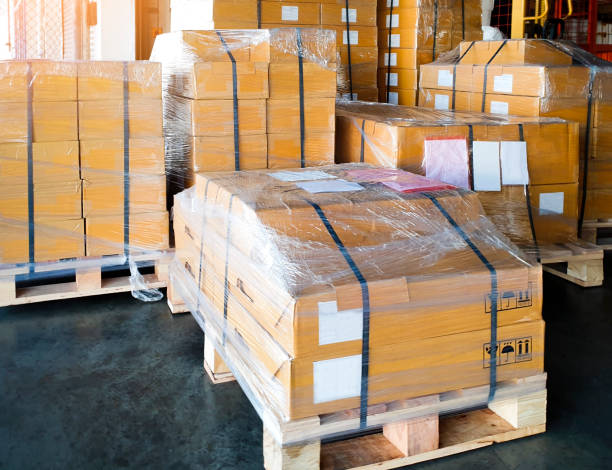istock Stack of cardboard boxes on wooden pallets. shipment boxes, interior of warehouse storage. 1251424889