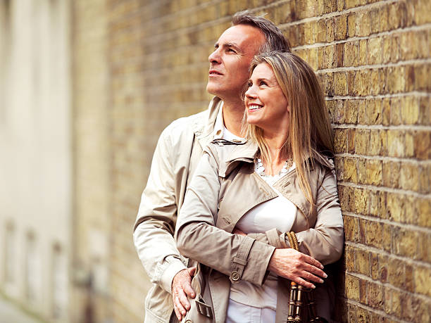 istock Smiling mature couple embracing and standing next to brick wall. 125142681