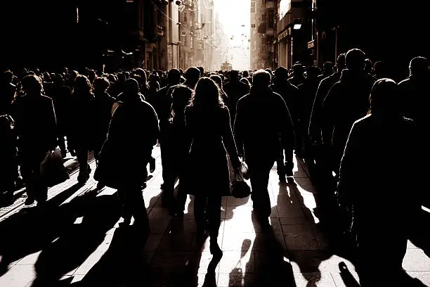 Photo of crowded people walking on busy street