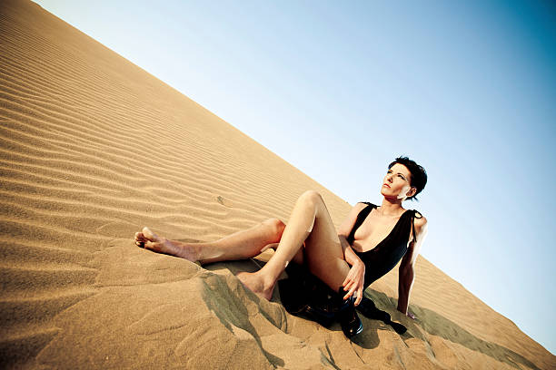 istock Woman sitting on sand dune 125142759