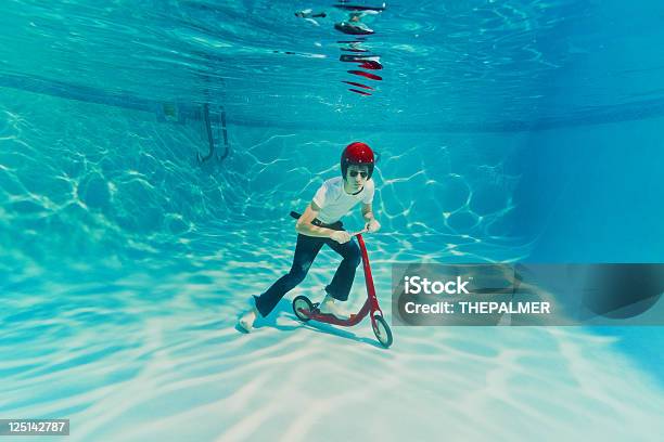 Teenager Pushing A Scooter Underwater Stock Photo - Download Image Now - Bizarre, On The Move, Activity