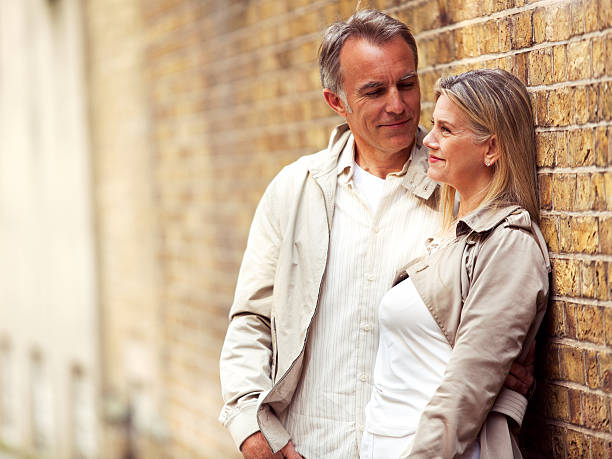 istock Smiling mature couple standing next to the brick wall 125142794