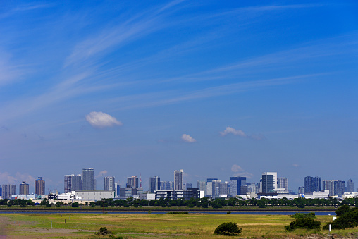 Tokyo Bay Area and urban skyline against blue sky.