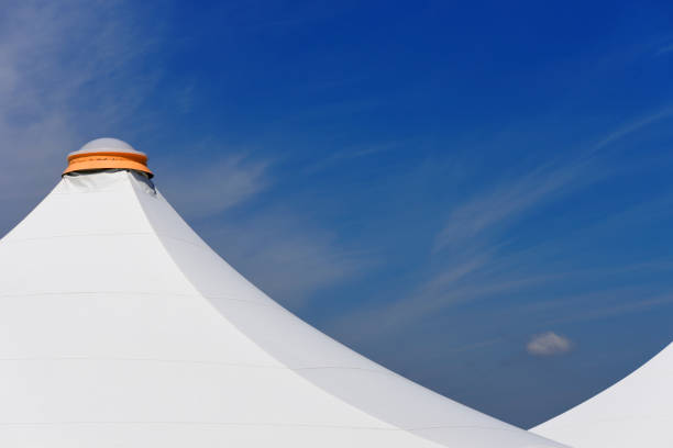 istock White big tent roof with sunlight against blue sky 1251428348