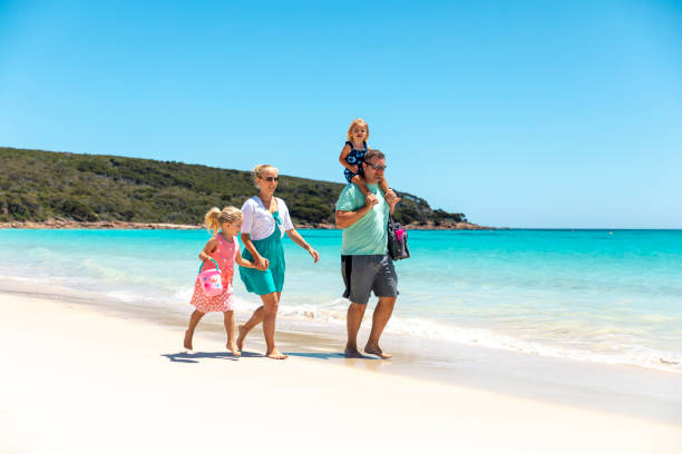 istock Family Walking Along the Beach 1251429025