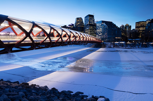 Image taken of the Peace Bridge stretching across the Bow River, early morning before sunrise. Low light, Image taken March/10/2020 on a tripod. peace bridge was designed by Spanish architect Santiago Calatrava, opened for public use on March/24/2012