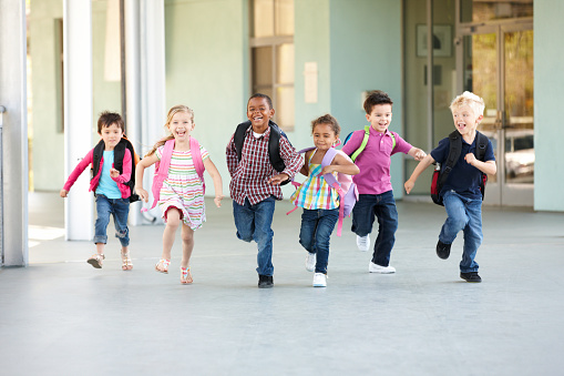Grupo de escolares de edad primaria corriendo afuera photo