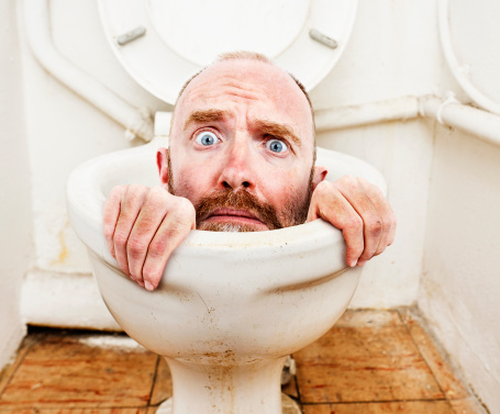 A desperate-looking man tries to claw his way out of a toilet bowl in this bizarre and humorous montage, symbolic of all kinds of problems.