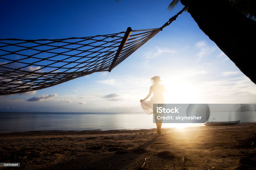 Женщина работает на пляже на красивый летний закат. - Стоковые фото Атрибут человека роялти-фри