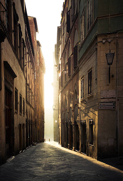 street in siena, italia-vacía en la mañana - narrow alley fotografías e imágenes de stock