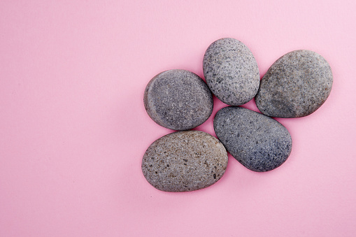 high angle view of five pebbles on pink background