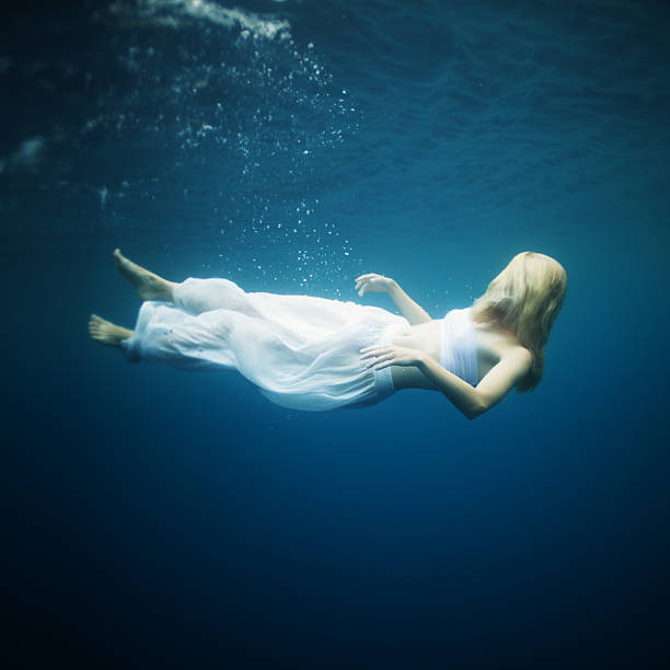 Young woman fall into deep water stock photo