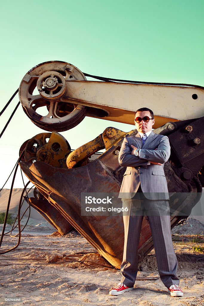 excavator cerca de un hombre de negocios de pie - Foto de stock de Actividad libre de derechos