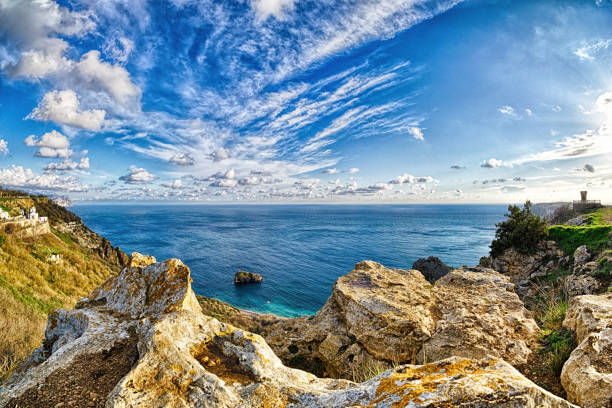 Panoramic seascape over the Jasper beach during sunset, with rocky cliff is lit by the warm sunset. Long exposure. Copy space. The concept of calmness silence and unity with nature