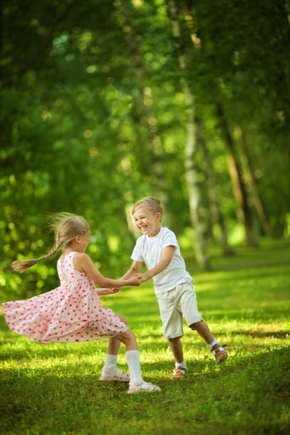 niños divirtiéndose en el parque - child dancing preschooler outdoors fotografías e imágenes de stock