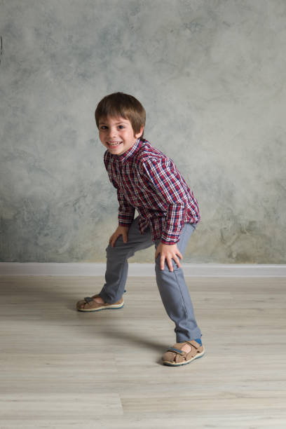 istock Young boy in plaid shirt standing in studio on the dark background. 1251444524