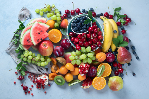 Fresh healthy fruits on grey background. Foods high in antioxidants, carbs,  minerals and  vitamins. Food for immune boosting. Top view