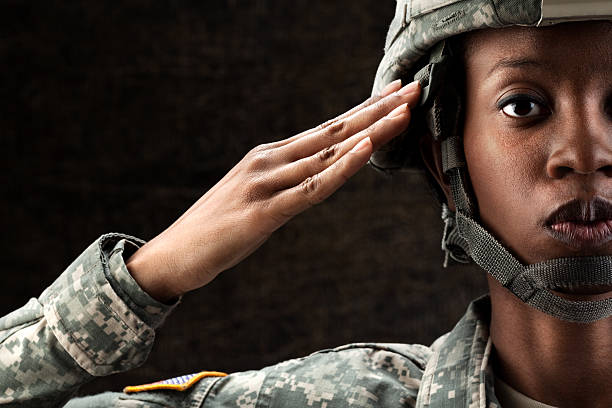 femme afro-américaine soldier series: contre fond marron foncé - faire le salut militaire photos et images de collection