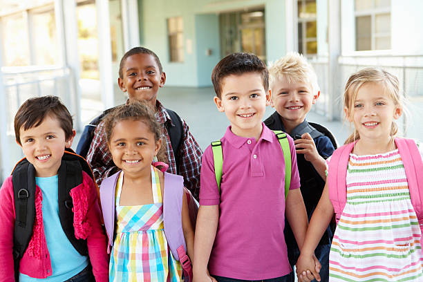 Group Of Elementary Age Schoolchildren Standing Outside Group Of Elementary Age Schoolchildren Standing Outside School Building primary age child stock pictures, royalty-free photos & images