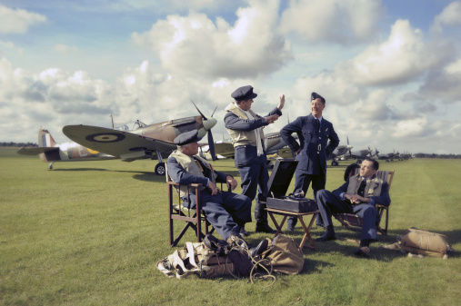 Word War 2 Royal Air Force Spitfire pilots discuss tactics on an aerodrome in England. The picture has been post processed with an antique effect.
