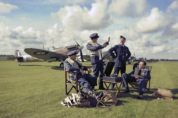 Spitfire Pilots Word War 2 Royal Air Force Spitfire pilots discuss tactics on an aerodrome in England. The picture has been post processed with an antique effect. pilot photos stock pictures, royalty-free photos & images