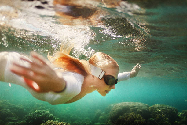 Young woman dive into deep water stock photo