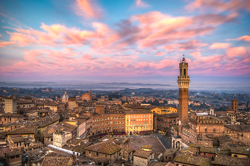 Siena cityscape at sunset, showing Piazza del Campo and Torre del Mangia.