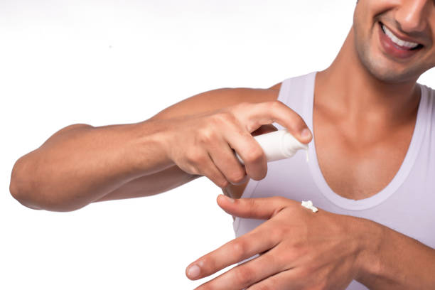 le mani di lavoro maschili indossano una crema idratante per una pelle morbida isolata su uno sfondo bianco, concetto di cura del corpo - men smooth the human body moisturizer foto e immagini stock