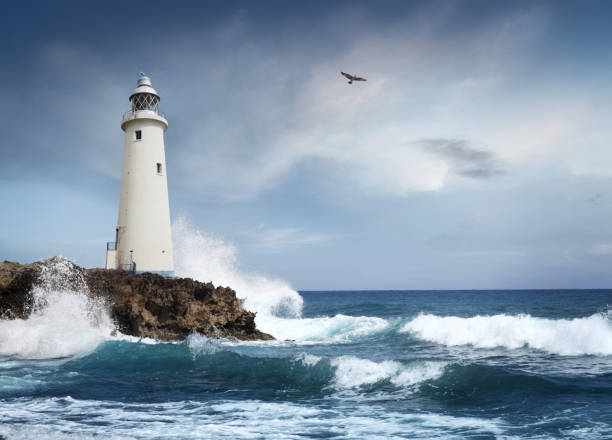 White lighthouse on the cliff White lighthouse in stormy weather on the cliff, photomontage. lighthouse stock pictures, royalty-free photos & images