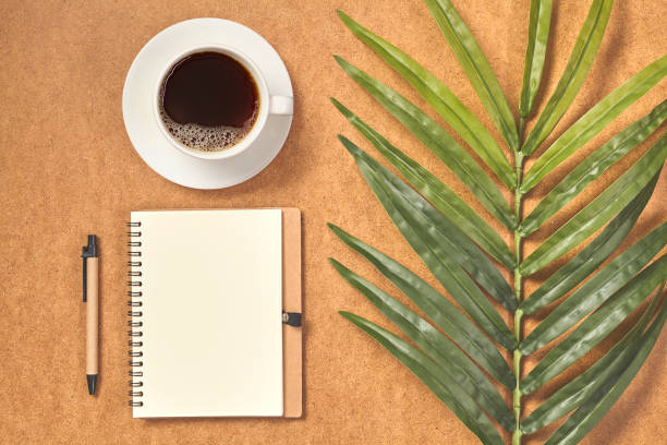 istock Cup of coffee, notebook and leaves on brown background. Top view, copy space. 1251451034