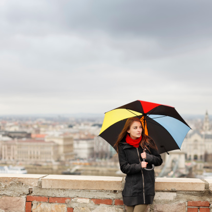 Girl with umbrella on a rainy day. City of Budapest in the background (defocused)